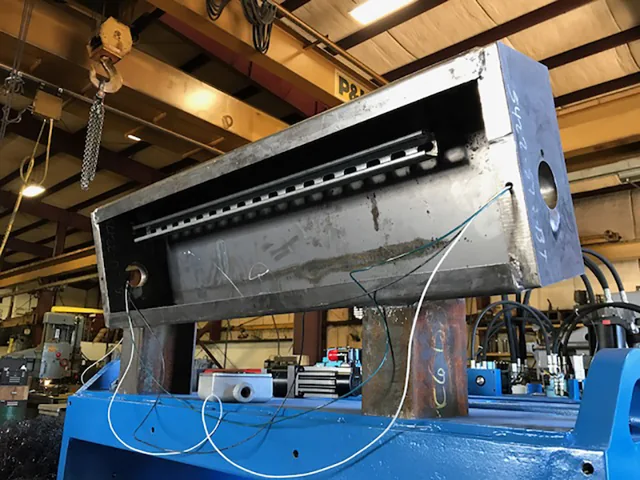 Large metal assembly above a blue machine base