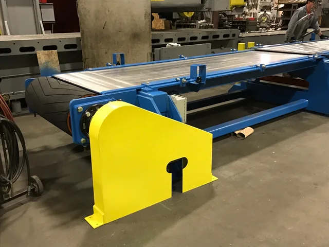 Long blue conveyor assembly with a yellow end guard