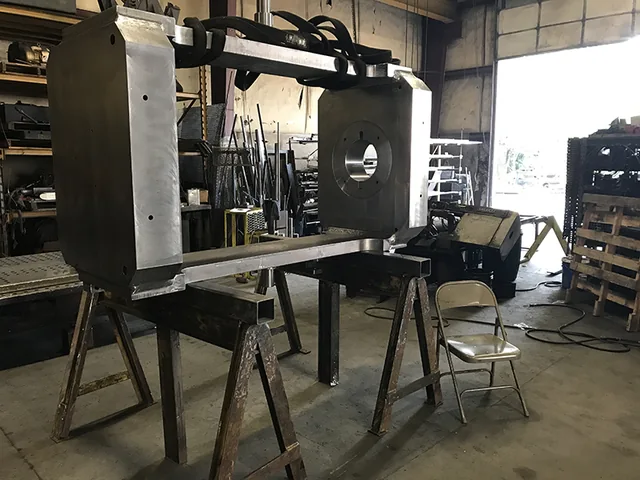 Rectangular metal frame supported on stands in the shop