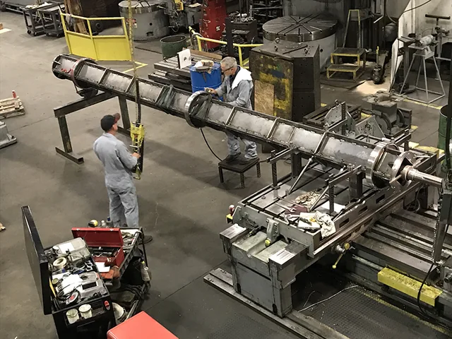 Long metal assembly supported above the shop floor