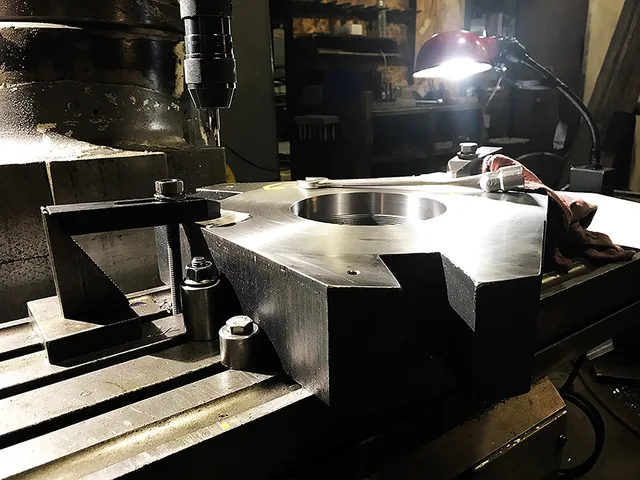 Metal workpiece with a circular opening secured on a machine bed