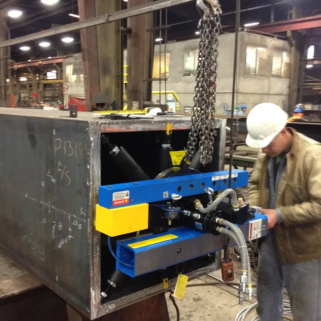 Worker beside equipment mounted on a large metal structure